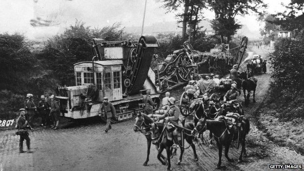 German troops manoeuvre a trench cutter along a country road.