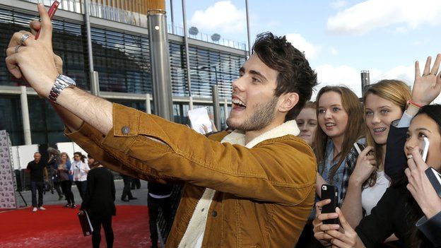 Alfie Deyes taking a selfie with fans
