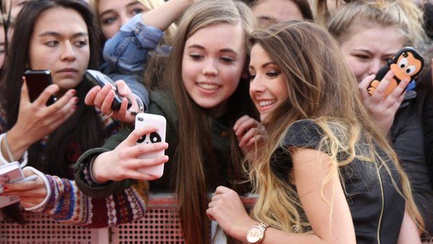 Zoella taking a selfie with fans