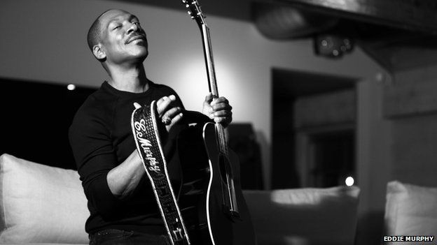 Eddie Murphy poses with a guitar