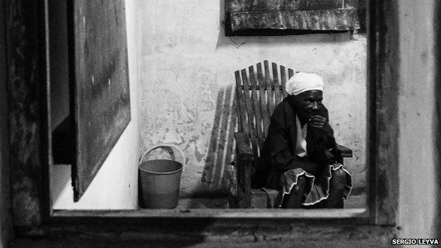Lone woman photographed through window in Perico