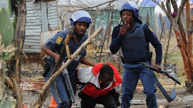 South African police arrest a miner in Marikana on 15 September 2012