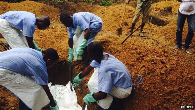 Volunteers bury the body of an Ebola victim in Sierra Leone