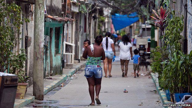 A woman carries a baby in Vila Uniao in January 2015