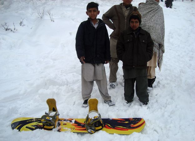 Two boys with a snowboard