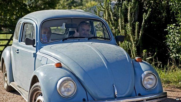 Uruguay's President Jose Mujica flashes a thumbs up as he and and his wife leave their home on the outskirts of Montevideo in their famous VW Beetle - 2 May 2014