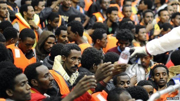 Migrants from Sub-Saharian areas receive bottles of water on a rescue boat of Italy's Navy ship San Giorgio after being rescued in open international waters in the Mediterranean Sea between the Italian and the Libyan coasts May 14, 2014.