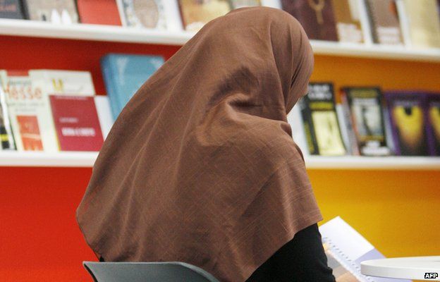 A veiled woman reads a book in front of shelves at the stand of Macedonia at the Leipzig Book Fair, 18 March 2010