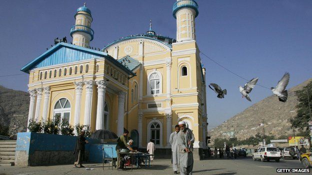 Afghan men feed pigeons in front of the Shad-u-Shamshera Walisaib mosque, in Kabul, 11 September 2005.