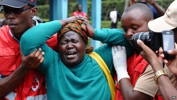 Kenya Red Cross staff assist a woman after she viewed the body of a relative killed in Thursday's attack Nairobi, Kenya, 3 April 2015