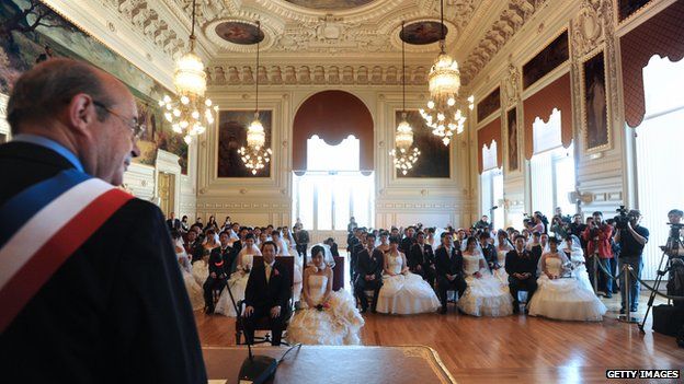 Tours mayor Jean Germain celebrates the wedding ceremony on behalf of young Chinese couples inside the city hall, in France Loire's Valley in October 2008.