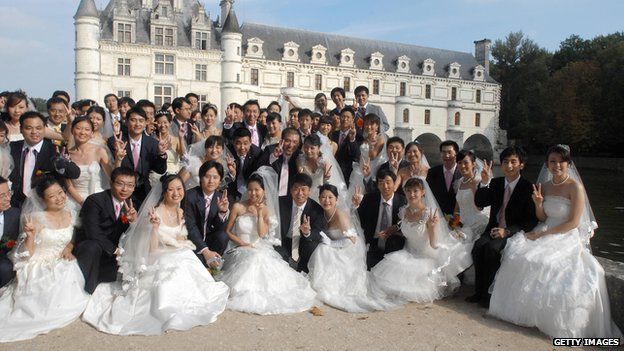 Chinese married couples coming from pose in front of Chenonceau castle, one of the most famous Loire's castles, after the confirmation of their wedding by Tours' mayor Jean Germain (not pictured), 09 October 2007