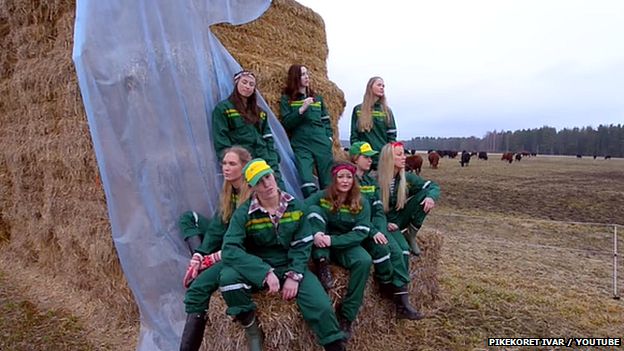 Norwegian girls gather around a bale of hay