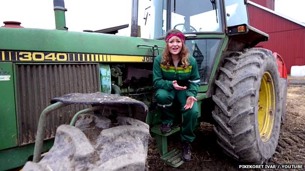 Norwegian girl perched at a tractor