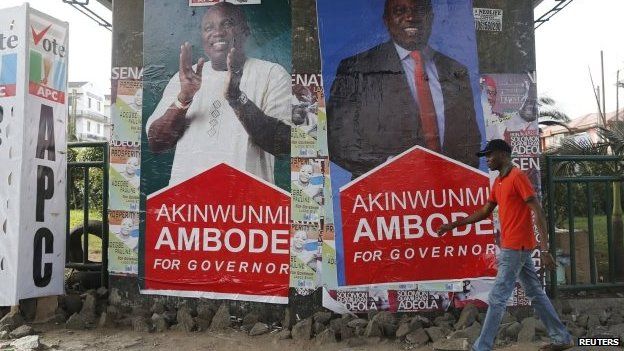 A man walks past banners campaigning for All Progressives Congress (APC) governorship candidate Akinwunmi Ambode, under a bridge in Lagos April 6, 2015