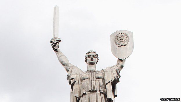 Motherland statue in Kiev, with a Soviet coat of arms on a shield