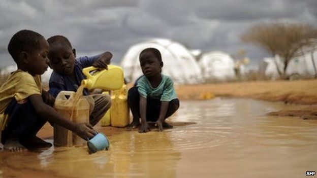 Somali boys fetching water from a puddle in Dadaab refugee camp in Kenya