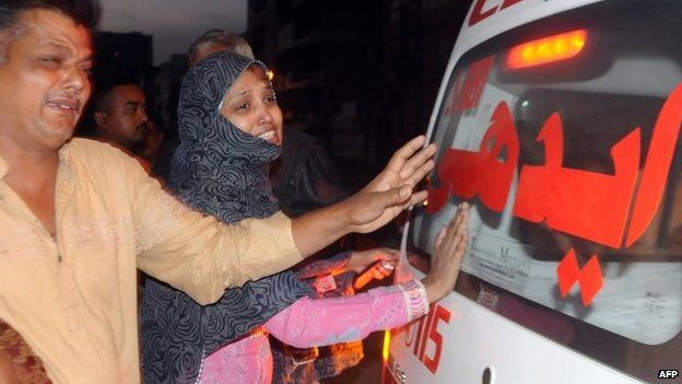Relatives beside an ambulance mourn convicted murder Muhammad Faisal after his execution in Karachi on 17 March