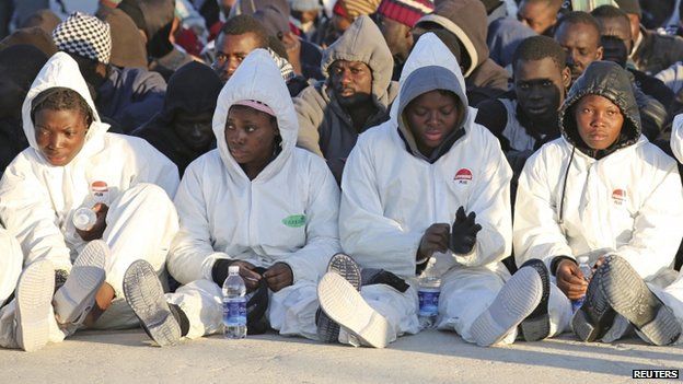 Migrants rest after they disembarked in the Sicilian harbour of Augusta, April 16, 2015