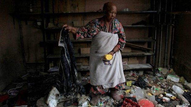 A woman sifts through rubbish inside her store, which she was renting to foreign nationals, after widespread xenophobic looting in Alexandra Township Johannesburg, South Africa, 18 April 2015