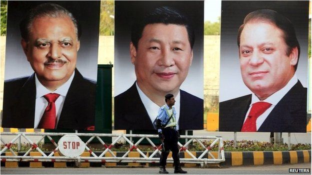 A policeman stands guard next to giant portraits of (L-R) Pakistan's President Mamnoon Hussain, China's President Xi Jinping, and Pakistan's Prime Minister Nawaz Sharif in Pakistan (19 April 2015)