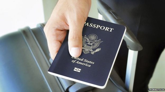 US passport and luggage in the hand of a traveller