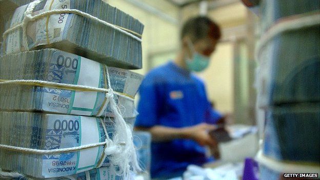 An employee of BNI Bank prepares rupiah banknotes for ATMs and branch offices