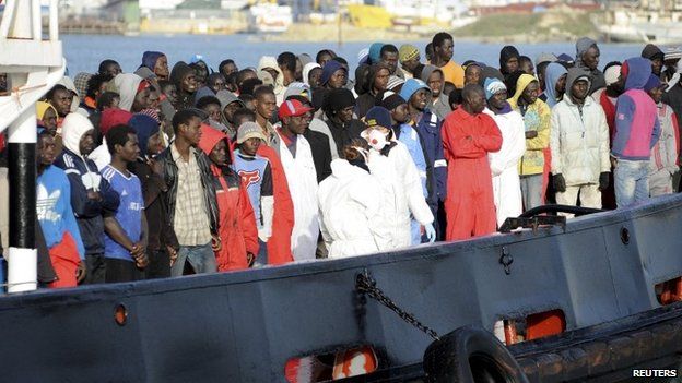 Migrants wait to disembark from a tug boat in the Sicilian harbour of Trapani, April 17, 2015