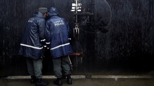 Afghan police soldiers watch a protest demanding justice for Farkhunda