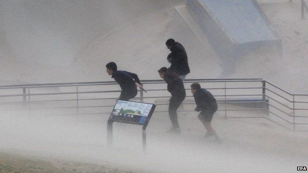 Boys try to take cover during heavy winds blowing sand onto the Bondi Beach promenade during heavy storms in Sydney, Australia, 21 April 2015.