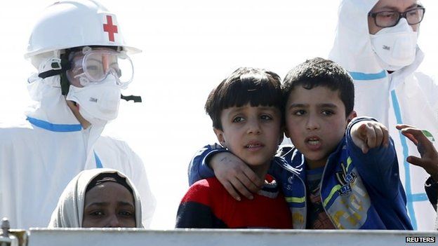 Children gesture on a ship landing on the Sicilian coast