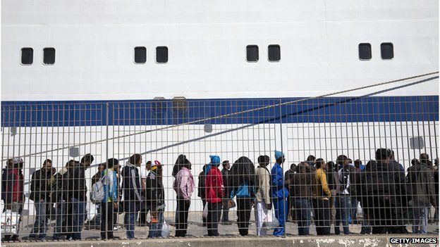 Migrant men wait to board a ship bound for Sicily in Lampedusa, Italy. 22 April 2015