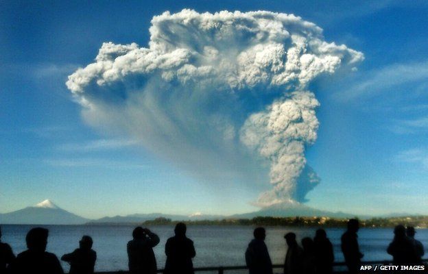 People watch from Puerto Varas, southern Chile, a high column of ash and lava spewing from the Calbuco volcano, 22 April 2015.