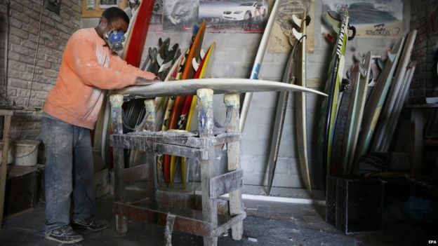 A Zimbabwean man repairing a surfboard, Cape Town, South Africa - Tuesday 21 April 2015