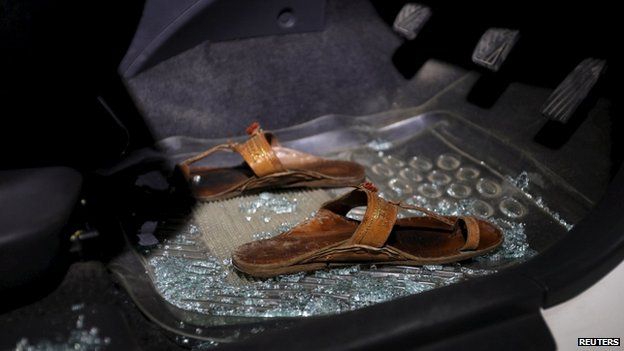 A pair of sandals lies amid broken glass in a car after a shooting incident in Karachi, Pakistan, April 25, 2015