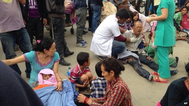 An injured man receives treatment outside the Medicare Hospital in Kathmandu, Nepal, Saturday, April 25, 2015