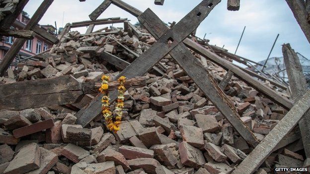 Flowers are left by survivors on top of debris from a collapsed building at Basantapur Durbar Square in Kathmandu (25 April 2015)