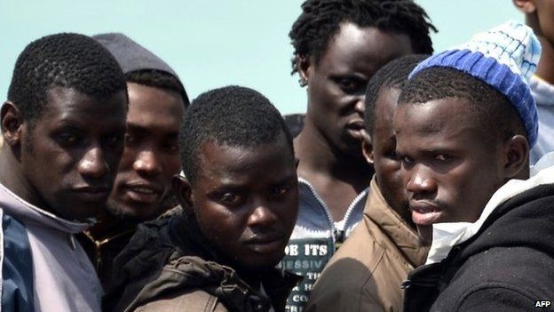 Rescued migrants wait before disembarking at Sicilian harbour of Catania on 24 April 2015