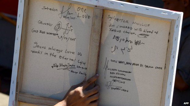 A relative displays the back of a recent painting done in prison by Australian drug convict and death row prisoner Myuran Sukumaran at the Nusakambangan port