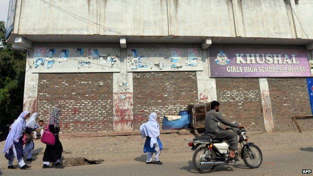 Pakistani female students walk past the school of child activist, Malala Yousafzai, in Mingora the capital of Swat Valley (23 Sept 2013)