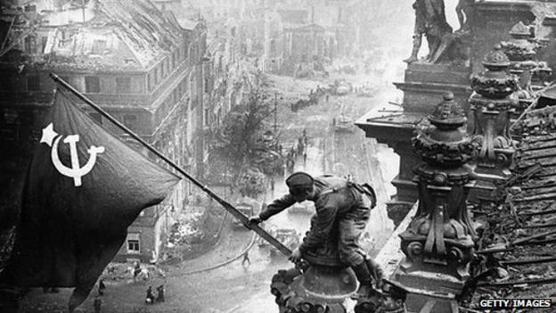 Red Army soldier raises the Soviet flag over the Reichstag in Berlin