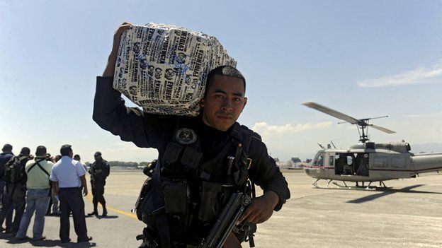 A police officer carries a package of seized cocaine at the air force base in Guatemala City on Febrary 23, 2013.