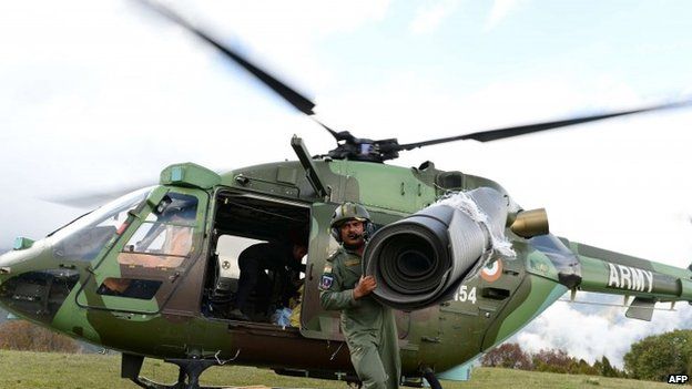 An Indian Army helicopter pilot unloads relief aid in the village of Laprak, in northern-central Gorkha district (30 April 2015)