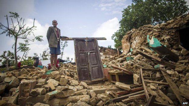 An elderly man stands on the ruins of his home in Paslang village in Gorkha, Nepal, on 20 April