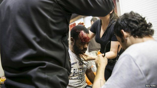 A protester, who is an Israeli Jews of Ethiopian origin, is treated for injury - Tel Aviv May 3, 2015