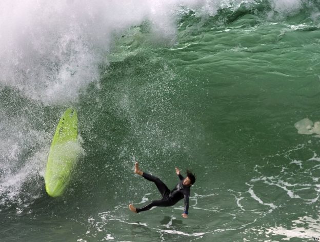 Man falling off surfboard