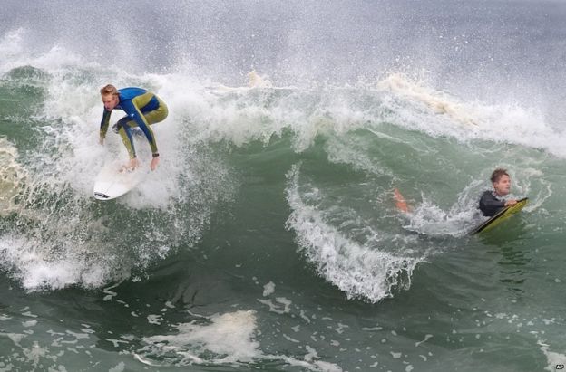 A surfer and a boogie-boarder on a wave