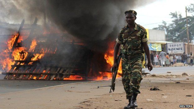 A soldier walks past a barricade erected on the road by demonstrators protesting against the ruling CNDD-FDD party's decision to allow Burundian President Pierre Nkurunziza to run for a third five-year term in office, in Bujumbura, 7 May 2015