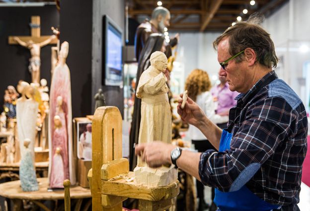 Man carving a sculpture from wood