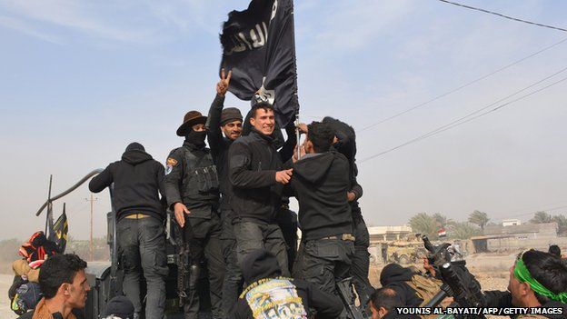 Iraqi government forces celebrate while holding an Islamic Sate group flag after they said they had gained complete control of the Diyala province, northeast of Baghdad, on 26 January 2015